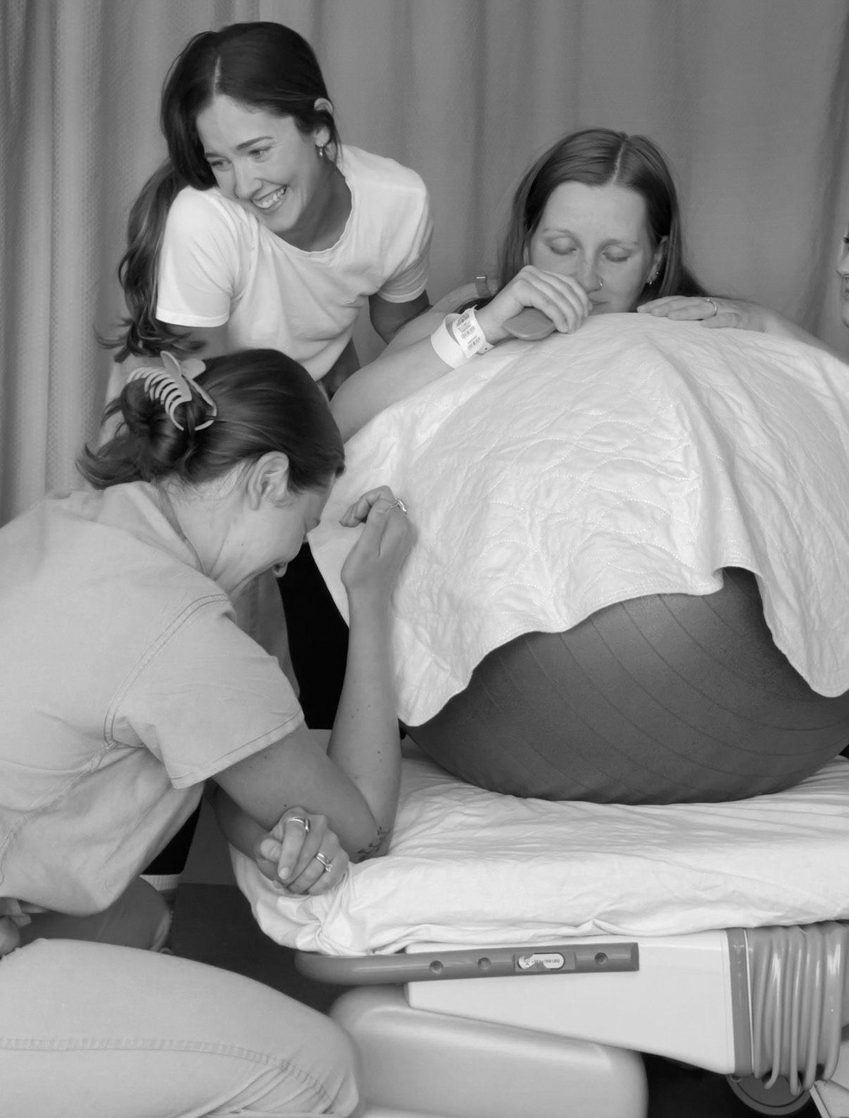 Abbie laughing with a laboring client and support team during birth