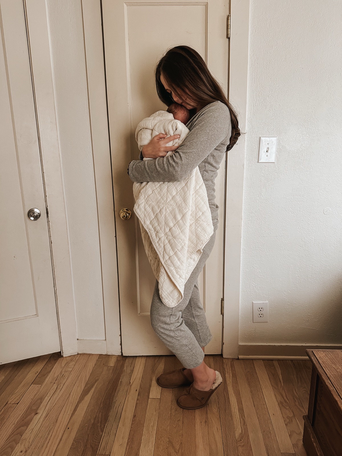 Abbie holding a newborn during a postpartum visit